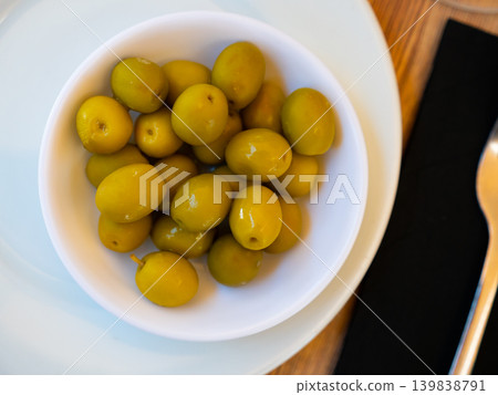 Trickle of pickled green olives on plate Trickle of pickled green olives on plate 139838791
