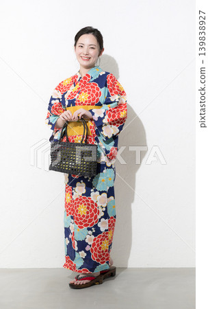 A full-body shot of a cute Japanese woman in a yukata against a white background, looking directly at the camera, suggesting a summery image of sightseeing, outings, or leisure activities in Japan. 139838927