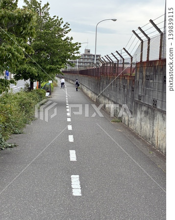 A girl walking home from school, in a town with a military base. A girl walking home from school, in a town with a military base. 139839115