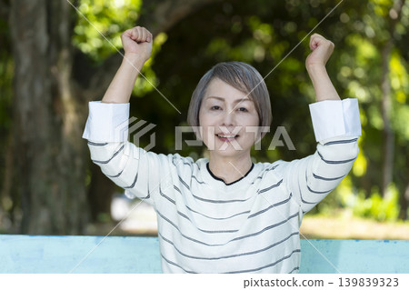 Senior women watching sports on a park bench surrounded by fresh greenery. Senior women watching sports on a park bench surrounded by fresh greenery. 139839323