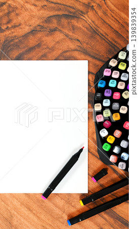 vertical shot of blank sheet and bright markers on wooden furniture vertical shot of blank sheet and bright markers on wooden furniture 139839354