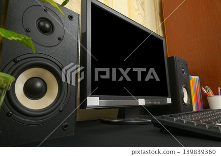 black audio speaker close up near a computer monitor on the desk black audio speaker close up near a computer monitor on the desk 139839360