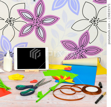 tablet on a table with colored paper crafts tablet on a table with colored paper crafts 139839371