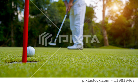Golfers are putting golf in the evening golf course golf backglound. Golfers are putting golf in the evening golf course golf backglound. 139839462