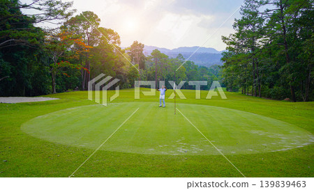 Golfers are putting golf in the evening golf course golf backglound. Golfers are putting golf in the evening golf course golf backglound. 139839463
