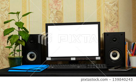 computer with a white screen on the desk among school supplies and a flower 139840243
