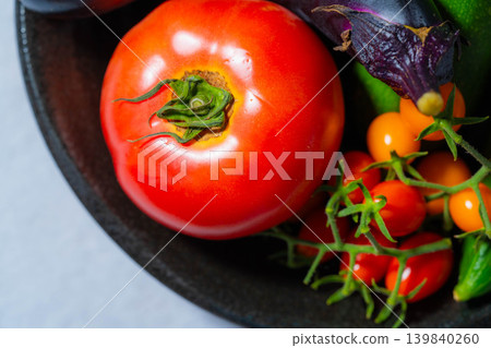 Assortment of fresh, dewy summer vegetables: tomatoes, eggplant, cucumbers, zucchini, and peppers 139840260