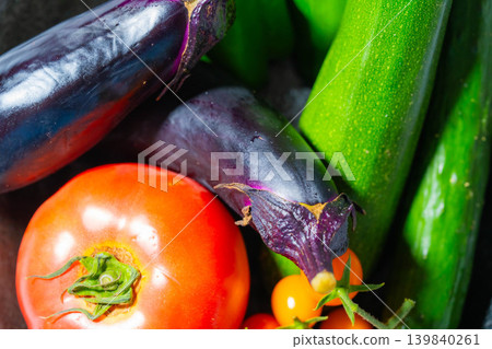 Assortment of fresh, dewy summer vegetables: tomatoes, eggplant, cucumbers, zucchini, and peppers Assortment of fresh, dewy summer vegetables: tomatoes, eggplant, cucumbers, zucchini, and peppers 139840261