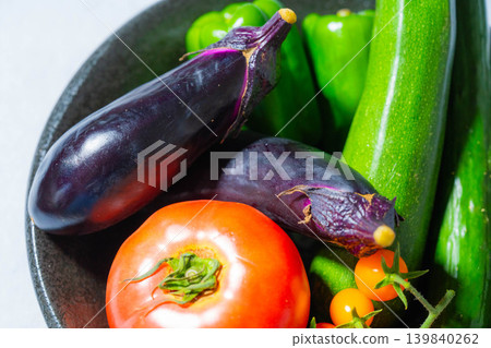 Assortment of fresh, dewy summer vegetables: tomatoes, eggplant, cucumbers, zucchini, and peppers 139840262