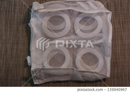 White Mesh Bag with Toilet Paper Rolls Inside White Mesh Bag with Toilet Paper Rolls Inside 139840967