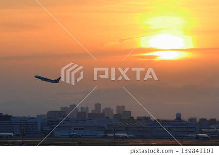 A passenger plane ascending against the backdrop of the setting sun. A passenger plane ascending against the backdrop of the setting sun. 139841101