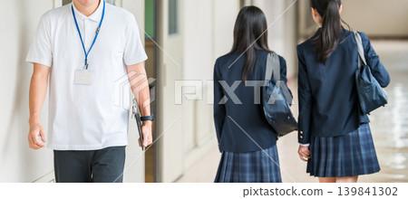 一位穿著 Polo 衫的男老師走在學校走廊裡 一位穿著 Polo 衫的男老師走在學校走廊裡 139841302