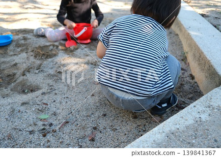 兩個幼兒在公園的沙坑玩玩具。 139841367