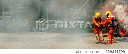 Firefighter Rescue training in fire fighting extinguisher. Firefighter fighting with flame using fire hose chemical water foam spray engine. Fireman wear hard hat, safety suit uniform for protection 139841799