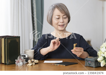 一位老婦人在客廳畫明信片。 一位老婦人在客廳畫明信片。 139841974