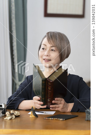 一位老婦人在客廳畫明信片。 一位老婦人在客廳畫明信片。 139842031