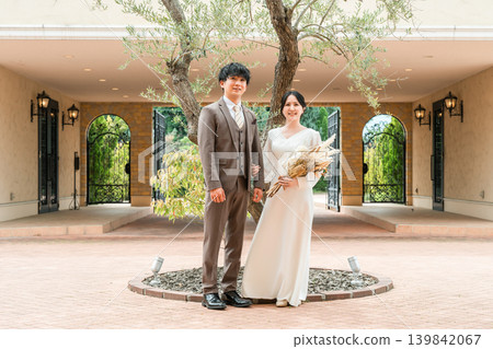新娘和新郎在婚禮儀式(花園婚禮)的婚禮大廳的花園裡拿著花束 新娘和新郎在婚禮儀式(花園婚禮)的婚禮大廳的花園裡拿著花束 139842067
