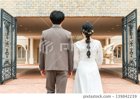 Back view of bride and groom walking into wedding hall (entrance, wedding) 139842239