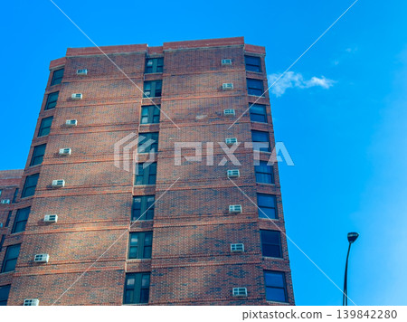 Building with many windows under clear blue sky observed from street level during midday Building with many windows under clear blue sky observed from street level during midday 139842280