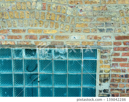 Exploring the textured wall with glass blocks at an outdoor location in a city under bright daylight Exploring the textured wall with glass blocks at an outdoor location in a city under bright daylight 139842286