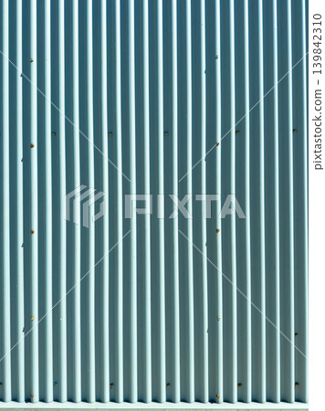 Metal wall with vertical lines and small marks captured during bright daylight at an outdoor location in a suburban area Metal wall with vertical lines and small marks captured during bright daylight at an outdoor location in a suburban area 139842310