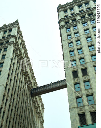 Historic buildings with a sky bridge connect two structures in a cityscape on a clear day Historic buildings with a sky bridge connect two structures in a cityscape on a clear day 139842393