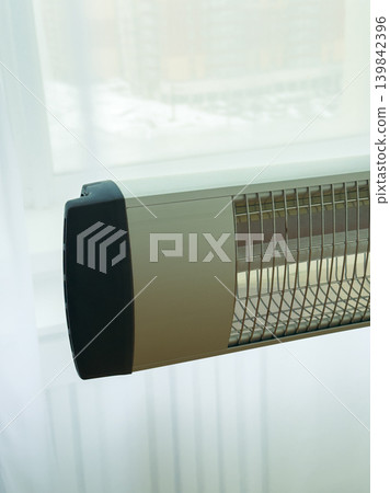 Heating unit installed near window with winter scenery outside at daytime Heating unit installed near window with winter scenery outside at daytime 139842396