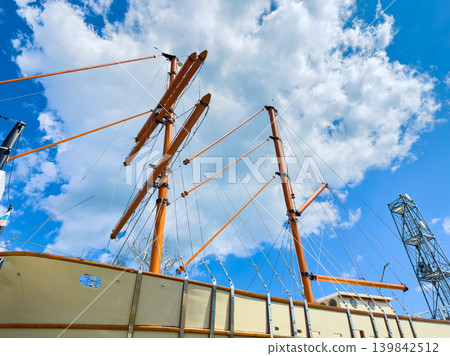 Tall ship masts and clouds on a bright day at the harbor Tall ship masts and clouds on a bright day at the harbor 139842512