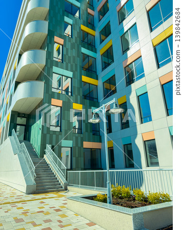 Building with modern design and colorful accents located in a city area during bright daylight hours Building with modern design and colorful accents located in a city area during bright daylight hours 139842684