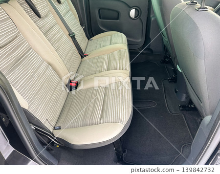 Interior view of the back seat area in a car showing the seating arrangement and carpet layout during daylight Interior view of the back seat area in a car showing the seating arrangement and carpet layout during daylight 139842732