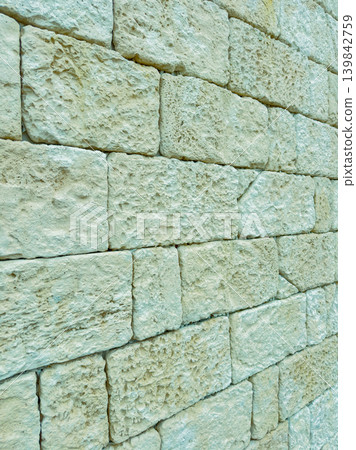Close view of stone wall showing texture and arrangement of blocks during daylight in an outdoor setting Close view of stone wall showing texture and arrangement of blocks during daylight in an outdoor setting 139842759