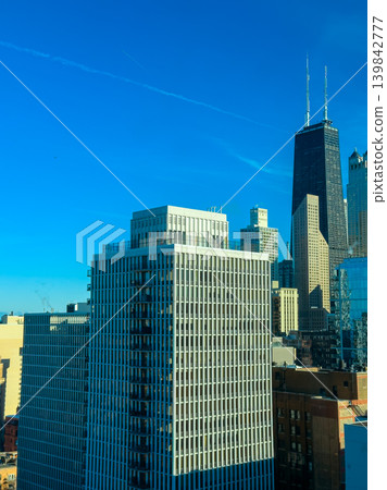City skyline with tall buildings and clear blue sky observed from a high vantage point in downtown Chicago during a bright afternoon City skyline with tall buildings and clear blue sky observed from a high vantage point in downtown Chicago during a bright afternoon 139842777