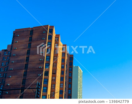 Building structure in city under blue sky showing detail of bricks and windows during daylight hours Building structure in city under blue sky showing detail of bricks and windows during daylight hours 139842779