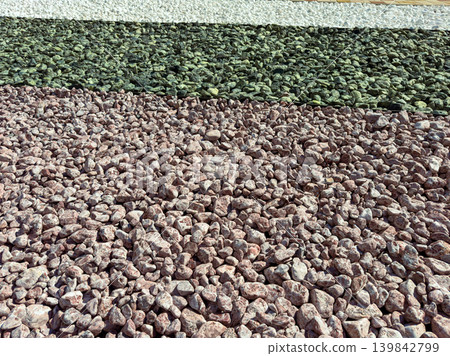 Colorful stones arranged in lines across a large area during daylight in a garden or landscaping project Colorful stones arranged in lines across a large area during daylight in a garden or landscaping project 139842799