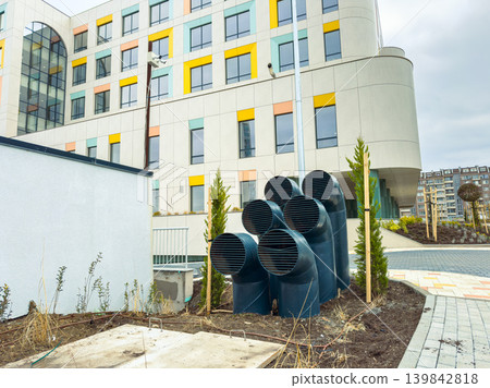 Construction site showing ventilation ducts next to a modern building in a city on an overcast day Construction site showing ventilation ducts next to a modern building in a city on an overcast day 139842818