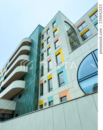 Modern building with colorful design in an urban area during daytime with clear sky and minimal clouds Modern building with colorful design in an urban area during daytime with clear sky and minimal clouds 139842833