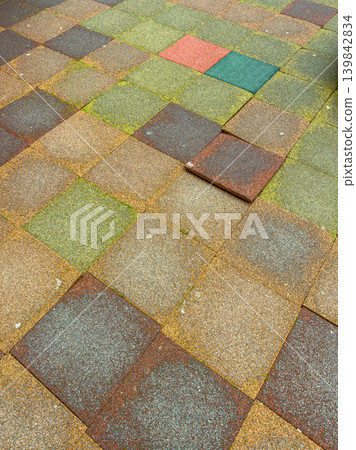 Colorful squares on a ground surface showing patches of grass and dirt near a playground during daylight hours Colorful squares on a ground surface showing patches of grass and dirt near a playground during daylight hours 139842834