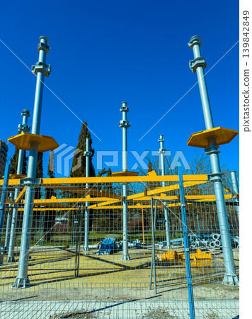 Construction site with metal supports and bright blue sky during daytime near a city park Construction site with metal supports and bright blue sky during daytime near a city park 139842849