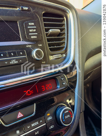 Dashboard display showing temperature and audio controls in a car during a clear day Dashboard display showing temperature and audio controls in a car during a clear day 139842876