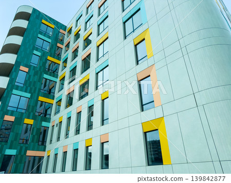 Colorful building design in an urban area showing modern architecture with windows and structured facade during daylight hours Colorful building design in an urban area showing modern architecture with windows and structured facade during daylight hours 139842877