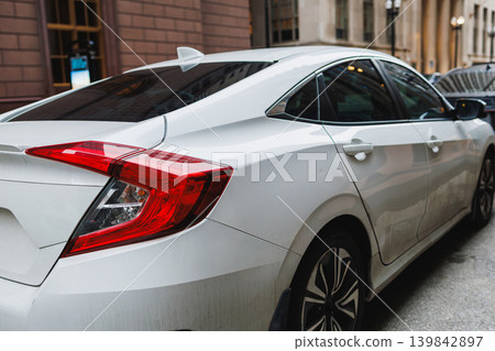 Car parked on a city street with buildings in the background during daytime hours 139842897