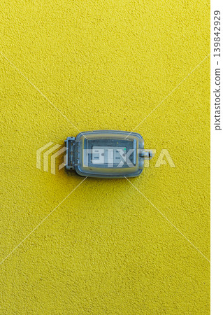 Electrical outlet mounted on bright yellow wall showing clear visibility of the connection point and safety design features in an urban setting Electrical outlet mounted on bright yellow wall showing clear visibility of the connection point and safety design features in an urban setting 139842929
