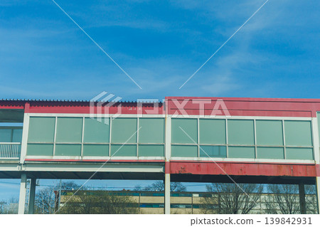 Walkway connects buildings in a city during bright daylight with clear skies and a blue backdrop Walkway connects buildings in a city during bright daylight with clear skies and a blue backdrop 139842931