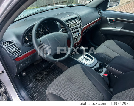 Interior view of a car showing dashboard, steering wheel, seats, and gear shift during daylight Interior view of a car showing dashboard, steering wheel, seats, and gear shift during daylight 139842983