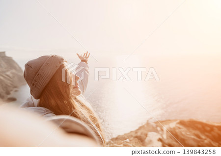 Woman freedom sunset smiling with arms outstretched at a coastal viewpoint during sunrise feeling joyful and inspired by natural beauty Woman freedom sunset smiling with arms outstretched at a coastal viewpoint during sunrise feeling joyful and inspired by natural beauty 139843258