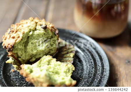 A matcha chocolate chip muffin cut in half and an iced café au lait A matcha chocolate chip muffin cut in half and an iced café au lait 139844242