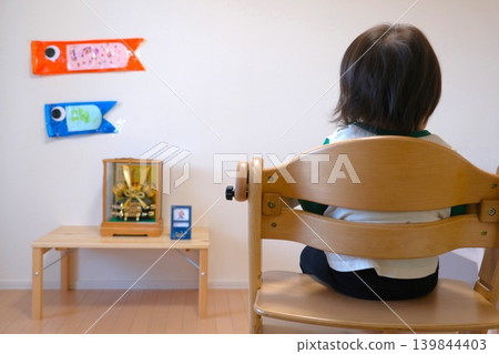 A May Festival doll displayed in the room, a handmade carp streamer, and the back view of a child. 139844403