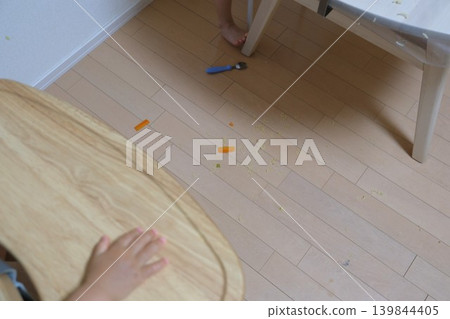 Food spills that fell on the floor and scattered during a child's meal. 139844405