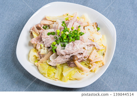 Steamed pork and cabbage in a frying pan, placed on the table. Steamed pork and cabbage in a frying pan, placed on the table. 139844514