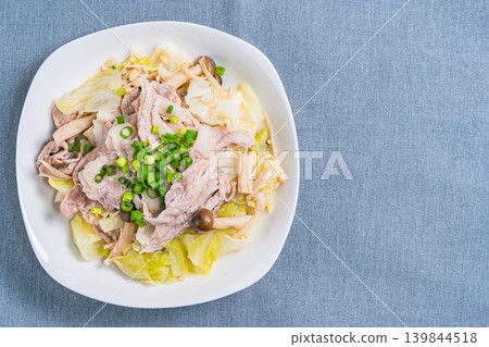 Steamed pork and cabbage in a frying pan, placed on the table. 139844518
